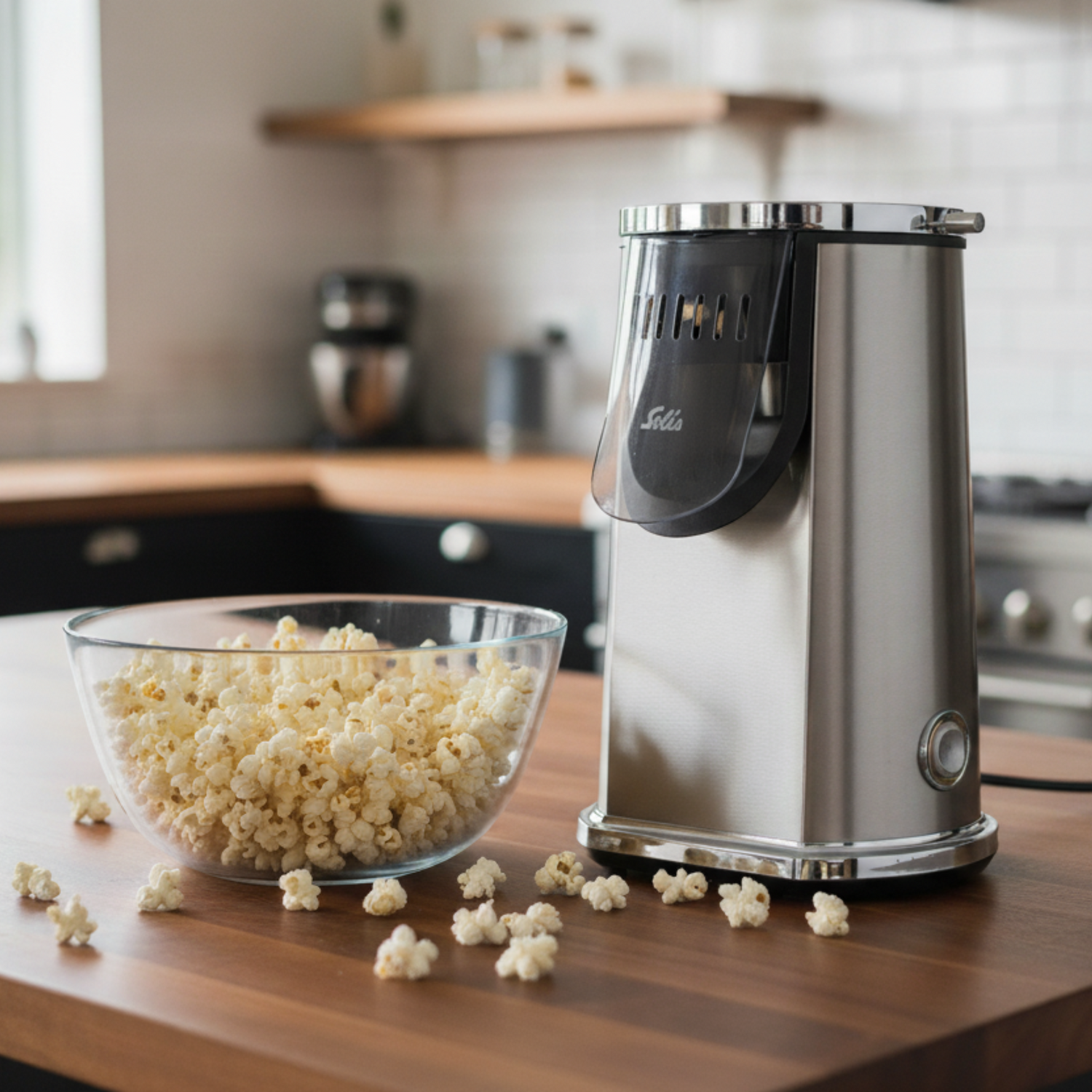 Solis Pop & Fun Popcorn Maker with fresh popcorn in a glass bowl on a wooden kitchen counter